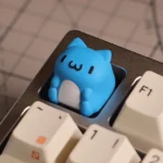 A whimsical close-up of the adorable, chubby Bugcat Capoo artisan resin keycap, highlighting its vibrant colors and sculpted SA profile.