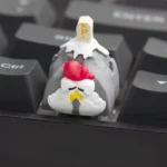 Close-up of a whimsical handcrafted resin Working Chicken Keycap, showcasing its unique details and vibrant colors from multiple playful angles.