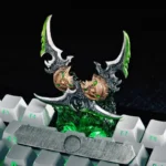 Close-up of the artisan World of Warcraft keycap, showcasing its hand-painted metallic finish and intricate dark fantasy details.