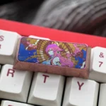 Premium Yae Miko titanium ice-crystal keycap from Genshin Impact, showcasing vibrant character art and iridescent effects on anodized titanium.