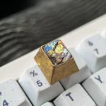 Close-up views of the premium Zenitsu titanium ESC artisan keycap, highlighting its intricate Demon Slayer design and metallic finish from multiple angles.