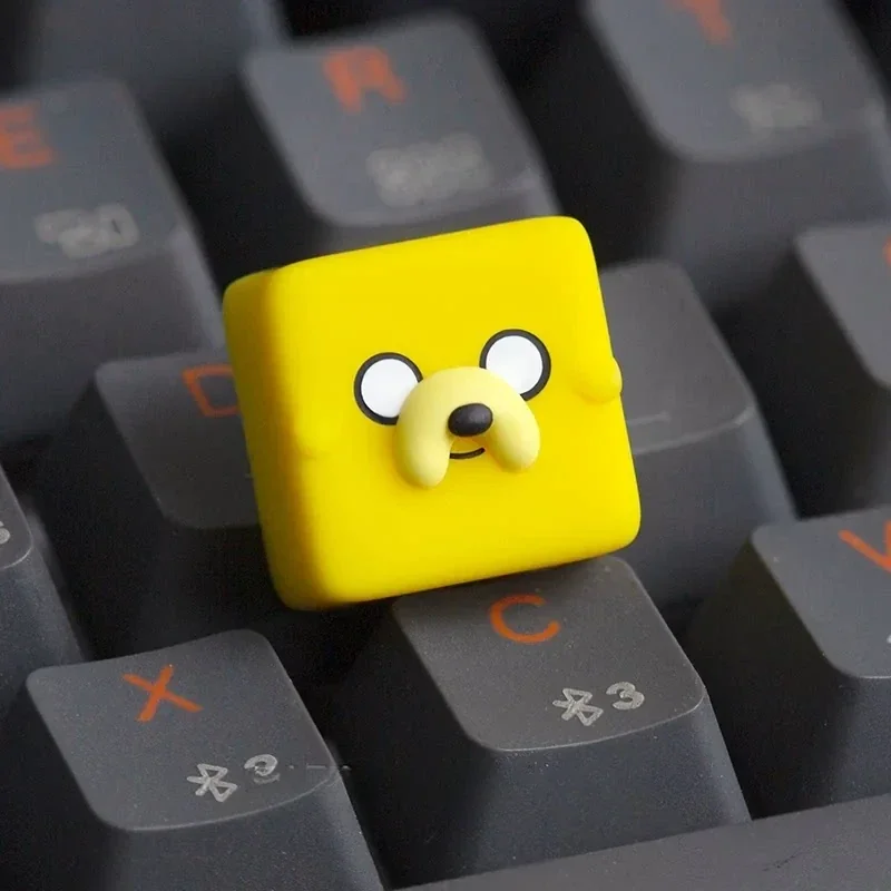 "Playful, handcrafted translucent resin Adventure Time Jake ESC keycap, glowing vibrantly with unique cartoon charm."