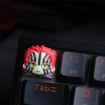 Close-up views of the handcrafted Demon Slayer Akaza artisan keycap, showcasing vibrant, detailed anime character art from multiple angles.