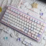 Adorable Angel Bear PBT MOA keycaps set from a playful angle, highlighting the soft pink aesthetic and charming angel graphics.