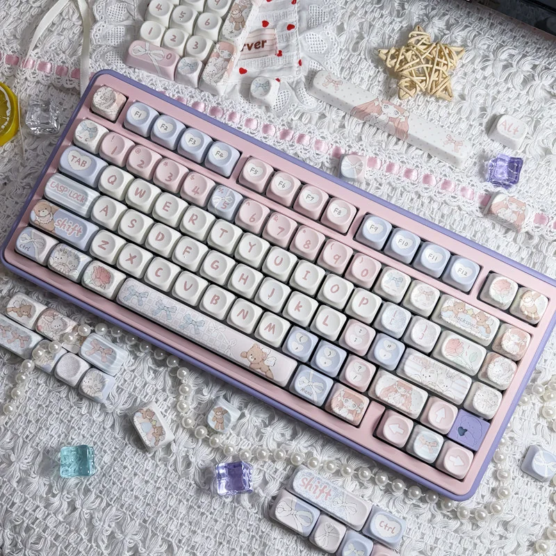 Adorable Angel Bear PBT MOA keycaps set from a playful angle, highlighting the soft pink aesthetic and charming angel graphics.