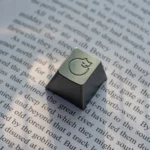 A handcrafted whimsical aluminum sleeping cat artisan ESC keycap, meticulously detailed, presented from an artistic angle emphasizing its premium metallic setup.