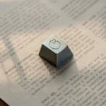 An angled view of the handcrafted aluminum sleeping cat artisan ESC keycap, revealing its serene metallic sheen and delicate, whimsical artistry.