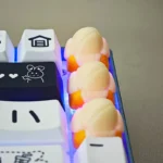 A vibrant yellow handcrafted banana resin keycap is playfully displayed, showcasing its whimsical miniature tropical fruit design and intricate detailed.