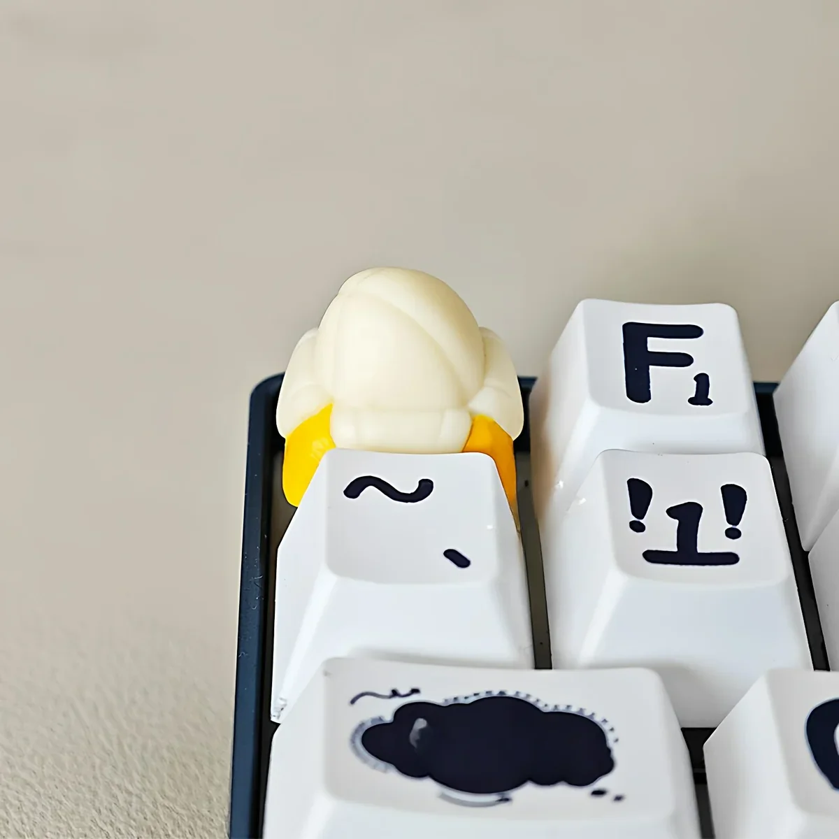 Vibrant yellow handcrafted banana resin keycap, a whimsical miniature tropical fruit, perfect for playful desk art.