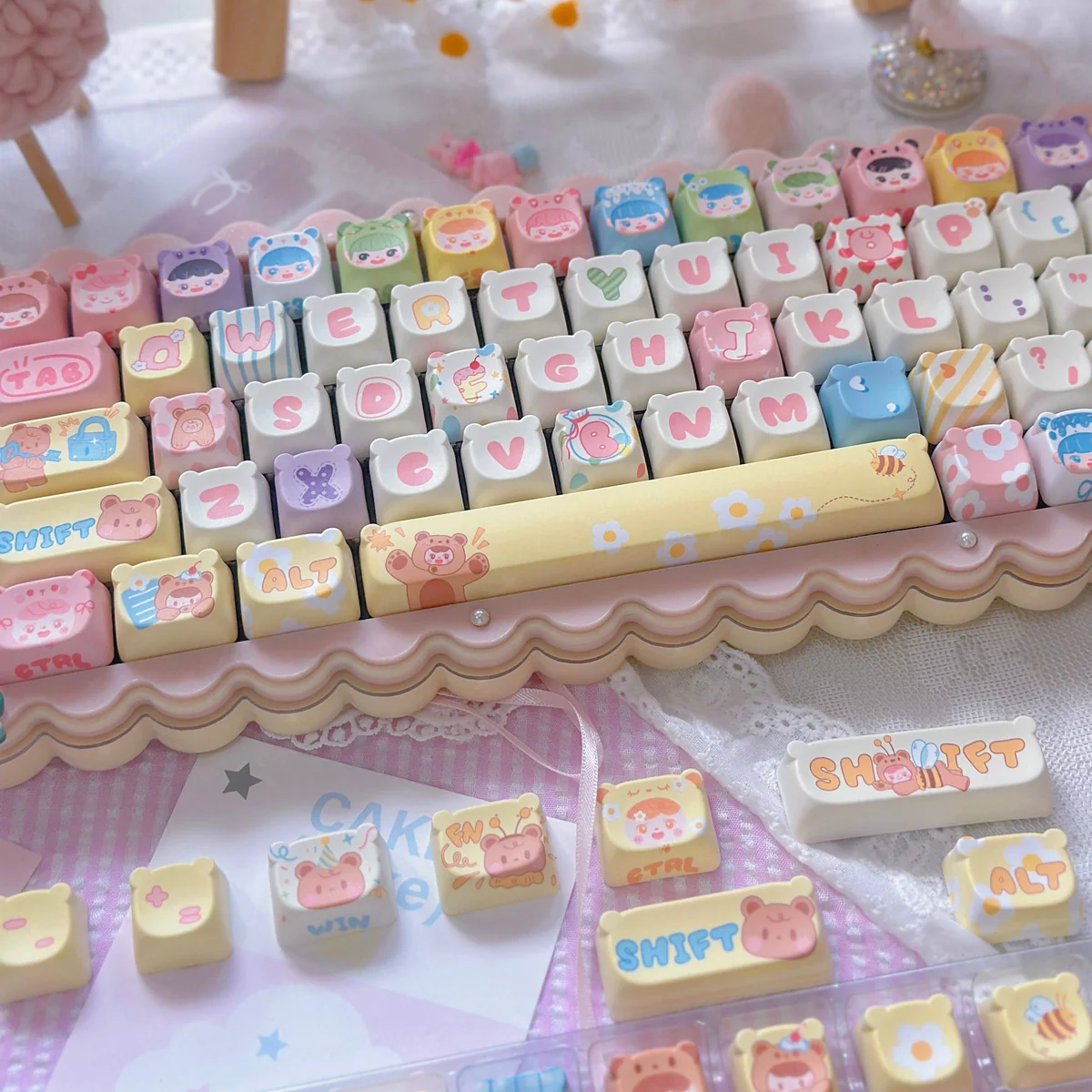 Close-up view of the whimsical bear doll keycap set from a side angle, showcasing the charming PBT MOA profile and playful cartoon design.