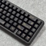 A close-up view of the ornate black and gold Baroque PBT keycaps set, showcasing intricate classical motifs and luxurious details from a unique angle.