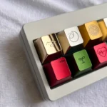 Multiple detailed views of the handcrafted solid brass pig keycap, revealing its warm golden luster and meticulously sculpted lucky charm design.