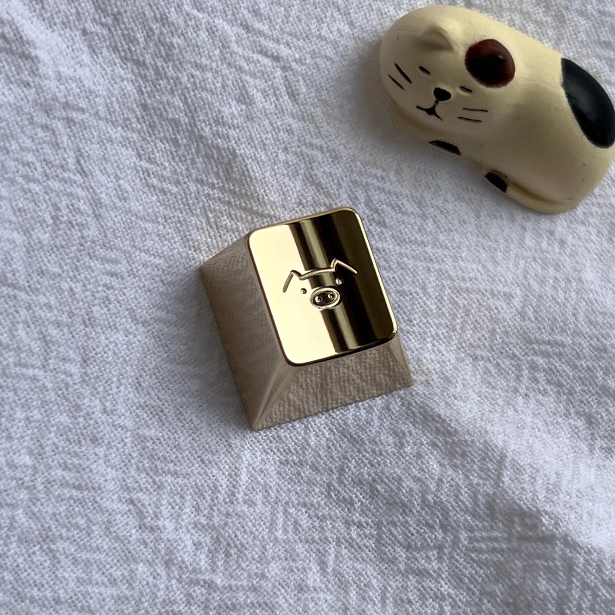 Close-up of a premium handcrafted solid brass pig keycap, meticulously sculpted with warm golden tones, bringing a lucky charm to a mechanical keyboard.