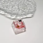 Nature's Bloom Butterfly Transparent Keycaps featuring a delicate black butterfly encased in vibrant red translucent resin, an artistic desk accessory.