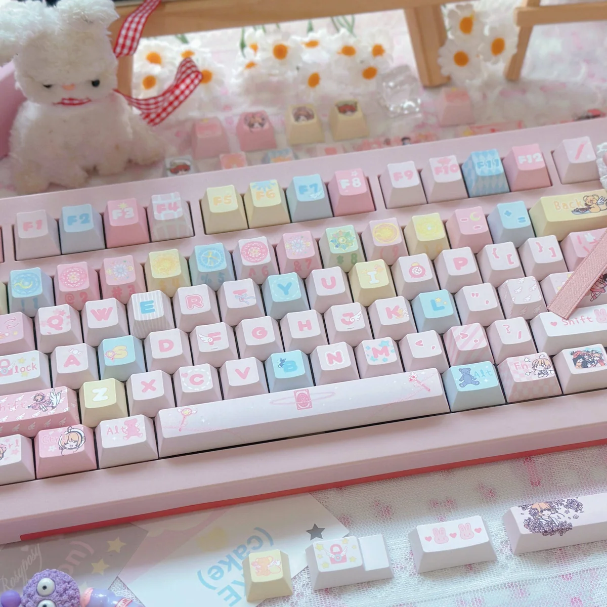 A vibrant Cardcaptor Sakura PBT keycap set displayed from a captivating angle, showcasing detailed anime characters and magical pastel symbols.