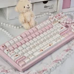 Delightful Cherry Cake PBT Keycaps set, featuring whimsical pastel pinks and charming cherry-cake designs. Enjoy durable joy and a sweet desk aesthetics.