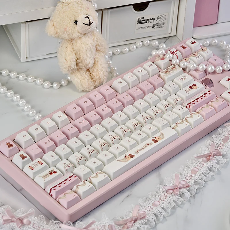 Delightful Cherry Cake PBT Keycaps set, featuring whimsical pastel pinks and charming cherry-cake designs. Enjoy durable joy and a sweet desk aesthetics.