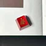 Close-up of a premium CNC aluminum Christmas tree keycap, showcasing intricate metallic details and delicate snowflakes from a unique angle.