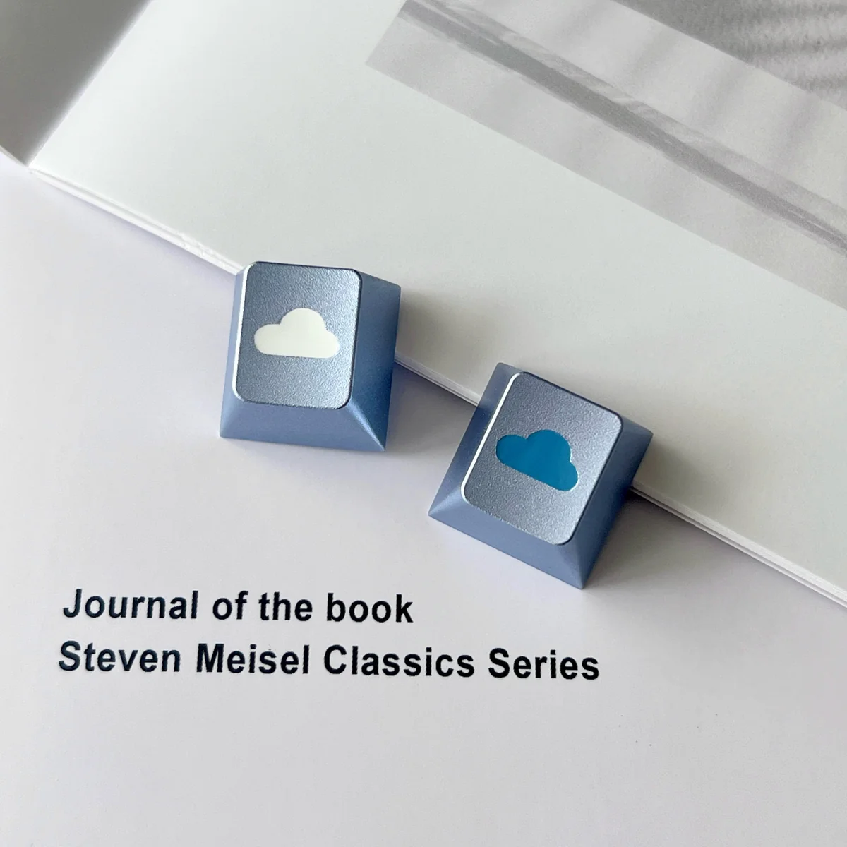 Premium CNC aluminum ethereal cloud artisan keycap, captured from a unique angle, revealing its polished finish and serene, minimalist R4 design.