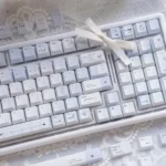 A close-up view of the Confession Keycap Set, showcasing the romantic pastel PBT dye-sublimated design. Soft hues and minimalist artistry evoke tender.