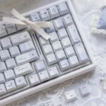 Close-up of Confession Keycaps Set, showcasing the romantic pastel PBT dye-sublimated set from an artistic side angle, emphasizing the gentle minimalist design.