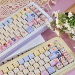 Whimsical Baby Zoraa Cute PBT Keycaps Set, showcasing durable PBT and adorable cartoon dolls in dreamy pastels from playful angles.