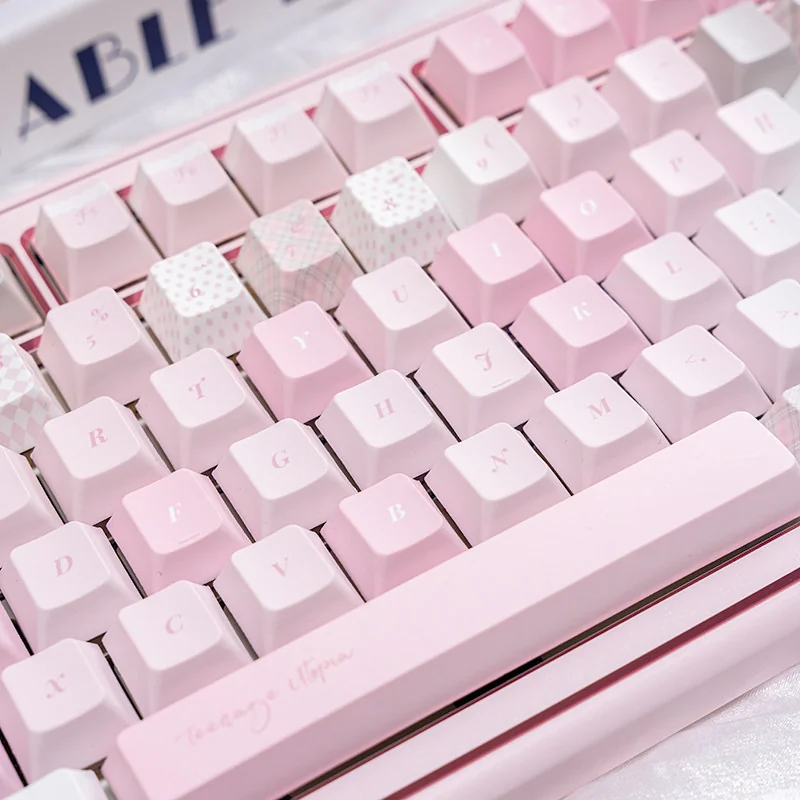 Close-up of the Dreamy Utopia cute pink PBT dye-sublimation keycap set, highlighting whimsical pastel motifs for a serene desktop setup.