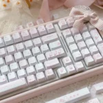 Charming Dessert Cat PBT Keycap Set, showcasing adorable pastel cats enjoying desserts from a detailed angle. Whimsical keyboard accent.