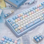 Playful Doraemon PBT dye-sub keycaps set, vibrant blue and white, featuring beloved characters and gadgets from a unique angle for nostalgic keyboards.