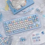 Vibrant blue and white Doraemon PBT dye-sub keycap set, showcasing playful characters and iconic gadgets from various angles.