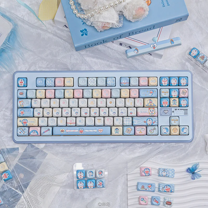 Vibrant blue and white Doraemon PBT dye-sub keycaps set showcasing beloved characters and iconic gadgets for a playful, nostalgic keyboard look.