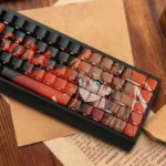 Vibrant red and orange EVA Asuka PBT keycaps with iconic side-lit legends, showcasing their translucent design for backlighting from diverse angles.