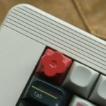 Artistic bright red plum blossom floral keycap crafted from precision CNC aluminum, a captivating artisan piece.