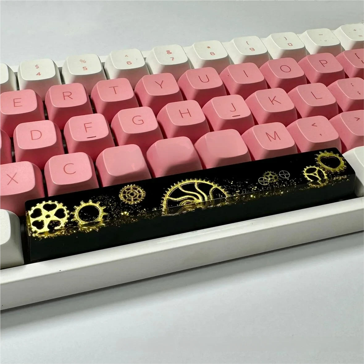 Artisan 6.25u resin gear Space Key keycap. Intricate industrial gears encased in dark, polished resin. This view highlights its solid feel and premium design.