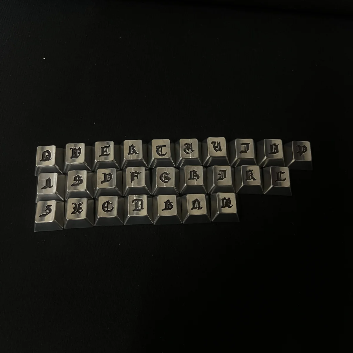 Handcrafted Gothic Alphabet Keycaps Set, showcasing intricate medieval-inspired craftsmanship from various angles. Dark, antique artistry for unique design.