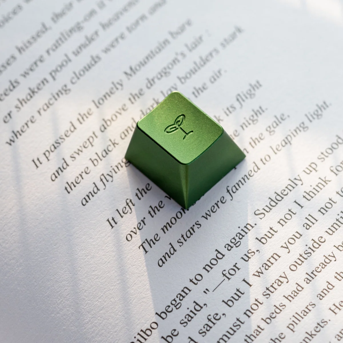 Vibrant Spring Bud Green Aluminum Artisan Keycap, Cherry R4, displayed from various angles, emphasizing its sleek metallic finish and intricately sculpted design.