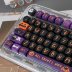 Vibrant Halloween PBT dye-sub keycaps set for mechanical keyboards. Playful pumpkins, ghosts, and bats on dark. High-quality set, shown from a fresh angle.