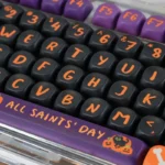 Vibrant Halloween PBT dye-sub keycaps set for mechanical keyboards, featuring playful pumpkins, ghosts, and bats from a unique angle on a dark background.