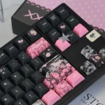 Close-up views of the unique Hello Kitty PBT dye-sub keycap set, showcasing its sweet yet edgy black and pink design from various playful angles.