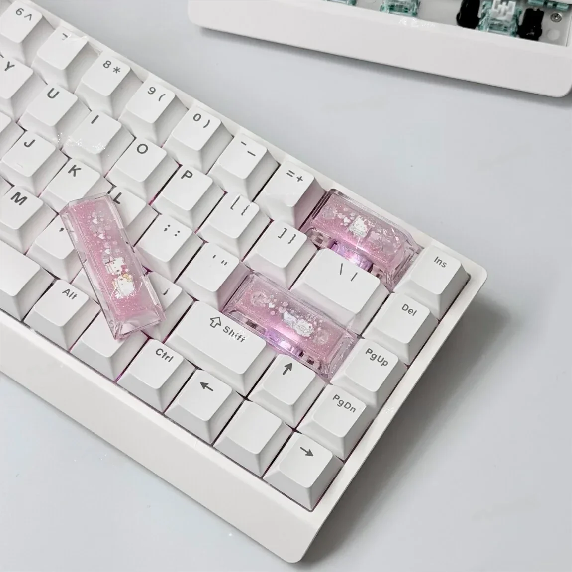 A collection of handmade Hello Kitty cherry profile accent keycaps in vibrant pink and white, displayed from various angles to highlight their charming design.