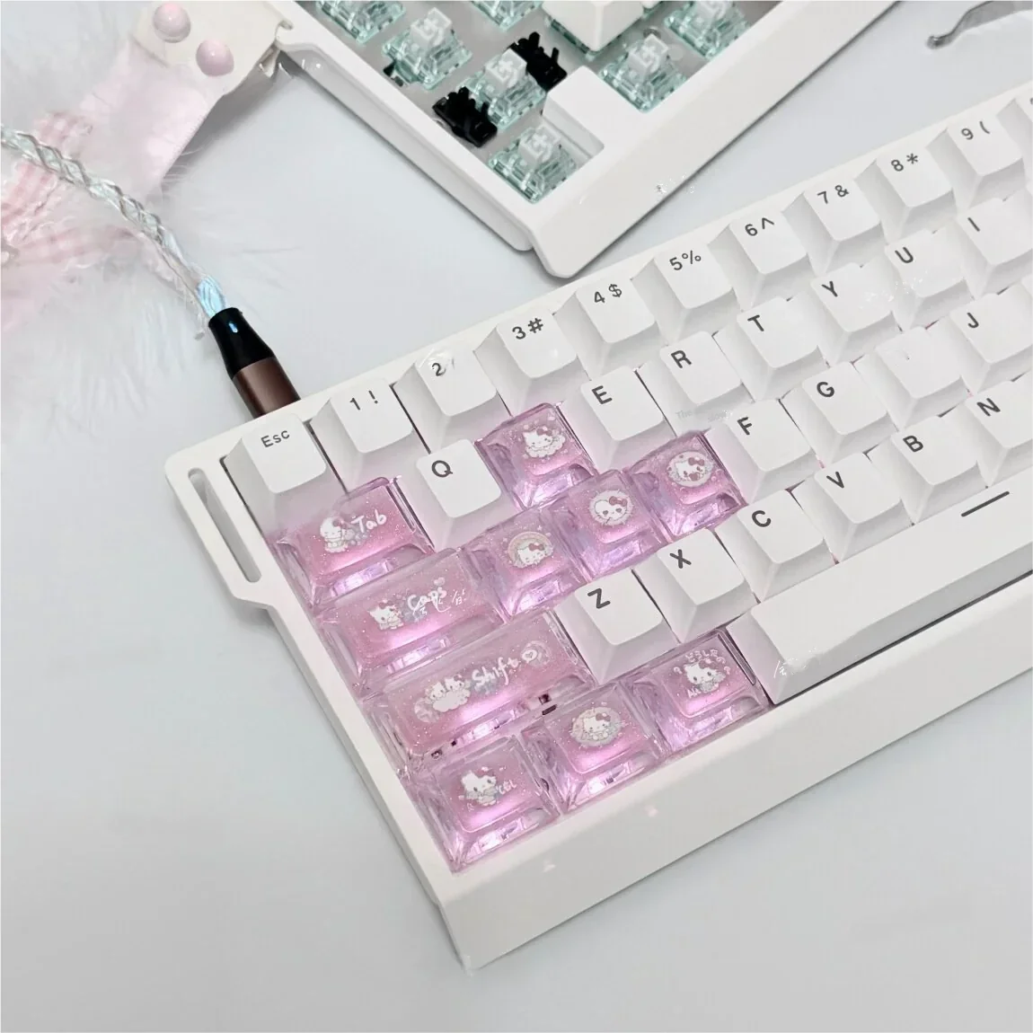 Handcrafted Hello Kitty cherry profile accent keycaps set, showcasing their whimsical pink and white designs from multiple angles, highlighting the iconic design.