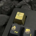 Close-up of a lustrous bright brass artisan Hi-Res Audio keycap, showcasing its precise CNC detailing for a premium, resonant HIFI typing experience.