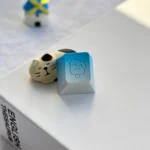 Detailed view of a whimsical handcrafted aluminum ice cream artisan keycap, highlighting its vibrant colors and polished metallic finish.