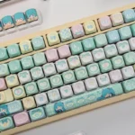 Vibrant Hatsune Miku PBT dye-sublimated keycaps set showcasing character art from different angles, perfect for a playful Vocaloid keyboard set.