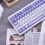 An artistic side view of Iris PBT keycaps set showcasing the ethereal dye-sub iris flower motifs and backlit glow, highlighting their elegant Cherry profile keycaps.
