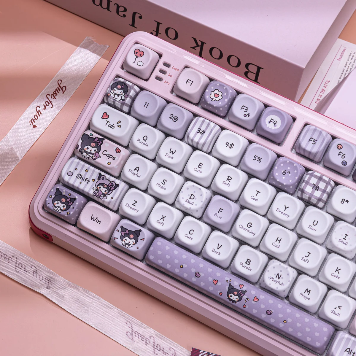 An overhead view of the exclusive Kuromi's Diary PBT Dye-Sub Keycap Set, showcasing the playful purple illustrations from the mischievous design.