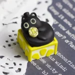 A close-up side view of the charming Lord of Mysteries Klein Cat artisan resin keycap, showcasing its intricate hand-sculpted details and mystical setup.