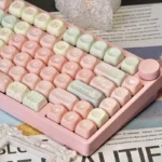 Whimsical Pink Gradient Melon MOA PBT Keycap Set shown from multiple angles. Features a sweet melon-inspired pastel pink to white fade for a cute keyboard.