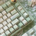 Detailed view of the Tranquil Moss Whisper PBT Dye-sub Keycaps Set, showcasing their serene moss-green hues and earthy tones for a nature-inspired keyboard.