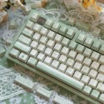 Tranquil Moss Whisper PBT dye-sub keycaps set in serene moss-green and earthy tones. This premium, nature-inspired keycap set elevates your desktop aesthetics.